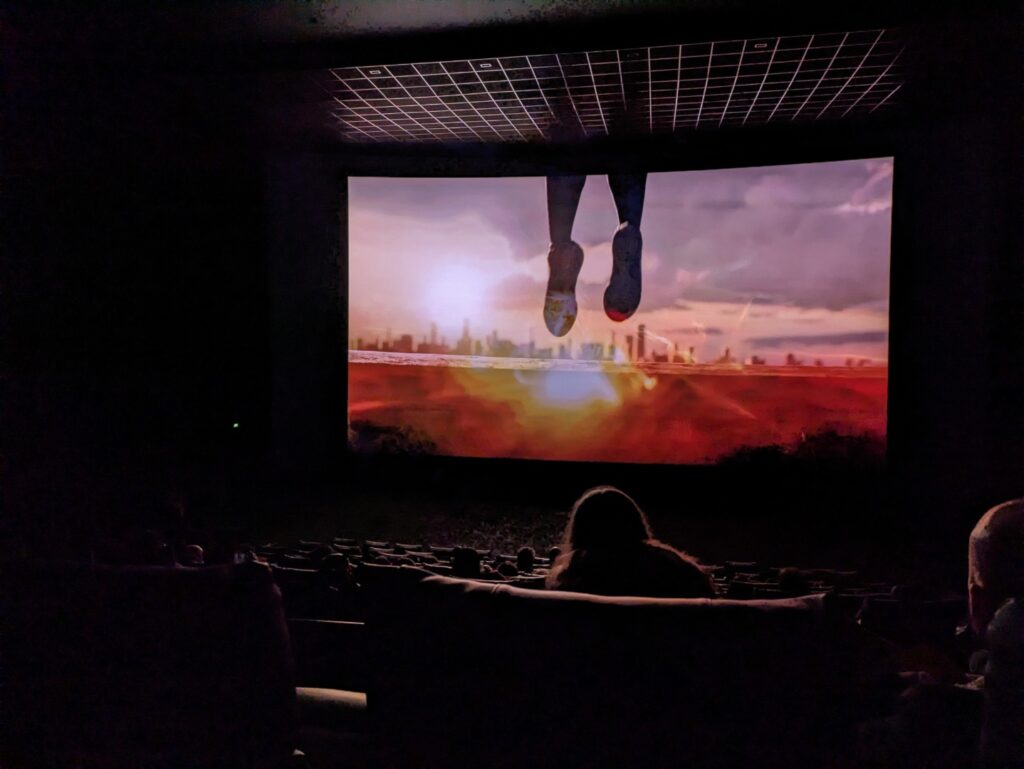 Cette photo a été prise dans le noir complet, avec un écran en mouvement. Le Pixel 7a réussit à voir les sièges de la salle et a arrêté la projection. // Source : Numerama