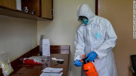 An Ugandan health officer prepares to take samples for testing a truck driver for COVID-19 (the novel coronavirus) at the Uganda&#39;s border post immigration in Malaba, a city bordering with Kenya, Uganda, on April 29, 2020. - All truck drivers ferrying goods crossing the border from Kenya must take a test for the COVID-19 by Ugandan health officials and wait 24 hours to get the result. After entering Uganda, the driver must stay inside the truck, only allowed to get off to unload at the destination. (Photo by Brian ONGORO / AFP) (Photo by BRIAN ONGORO/AFP via Getty Images)