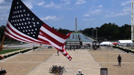 A man waves an American flag on top of the Lincoln Memorial ahead of civil rights &quot;2020 March on Washington&quot;, on August 27, 2020, in Washington, DC. - A civil rights rally timed to the 57th anniversary of the Rev. Martin Luther King Jr.&#39;s seminal I Have a Dream speech, delivered in 1963 from the steps of the Lincoln Memorial, is expected to bring thousands to the same spot on August 28, 2020. (Photo by Olivier DOULIERY / AFP) (Photo by OLIVIER DOULIERY/AFP via Getty Images)