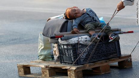 A woman pulls a baby on a pallet as they prepare to move to a new temporary camp for migrants and refugees, on the island of Lesbos, Greece, September 21, 2020. REUTERS/Yara Nardi     TPX IMAGES OF THE DAY