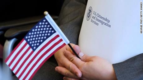 An applicant holds an American flag and a packet while waiting to take the oath to become a U.S. citizen at a Naturalization Ceremony on April 10, 2019 in Salt Lake City, Utah.