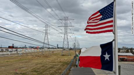 The U.S. and Texas flags fly in front of high voltage transmission towers on February 21, 2021 in Houston, Texas. Millions of Texans lost power when winter storm Uri hit the state and knocked out coal, natural gas and nuclear plants that were unprepared for the freezing temperatures brought on by the storm. Wind turbines that provide an estimated 24 percent of energy to the state became inoperable when they froze. (Photo by Justin Sullivan/Getty Images)