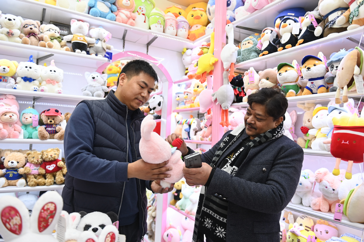 2023年2月2日，来自印度的客商（右）在义乌国际商贸城的一家玩具店铺内选购。