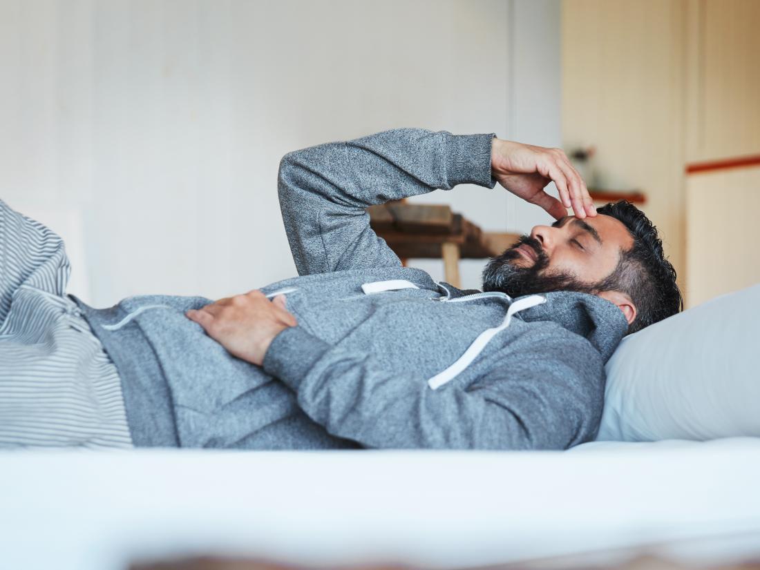 a man lying on his bed because of depression after surgery