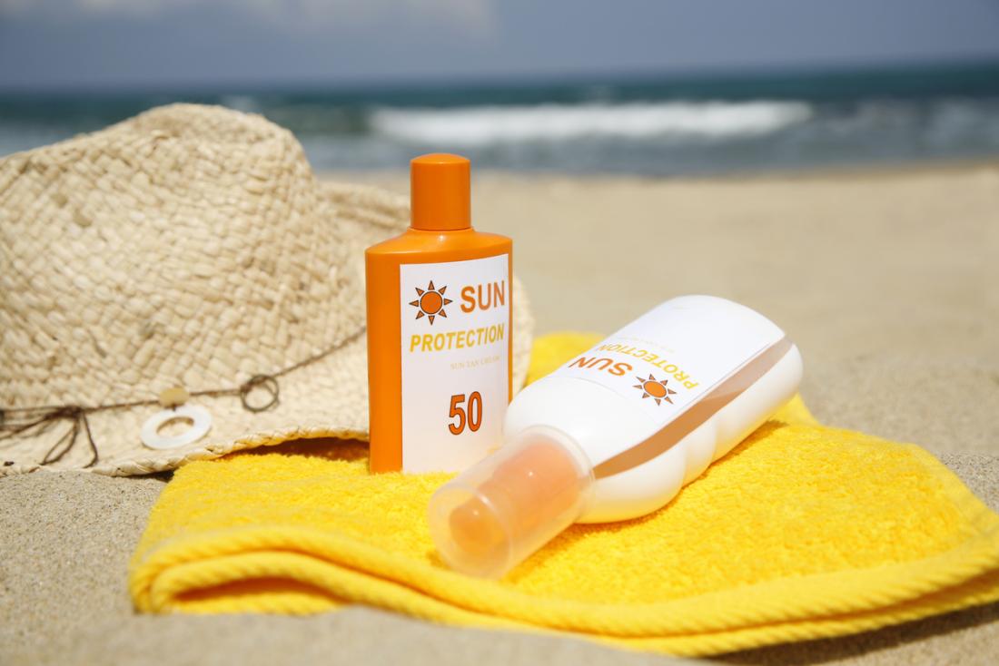 Sunscreen bottles on a beach.