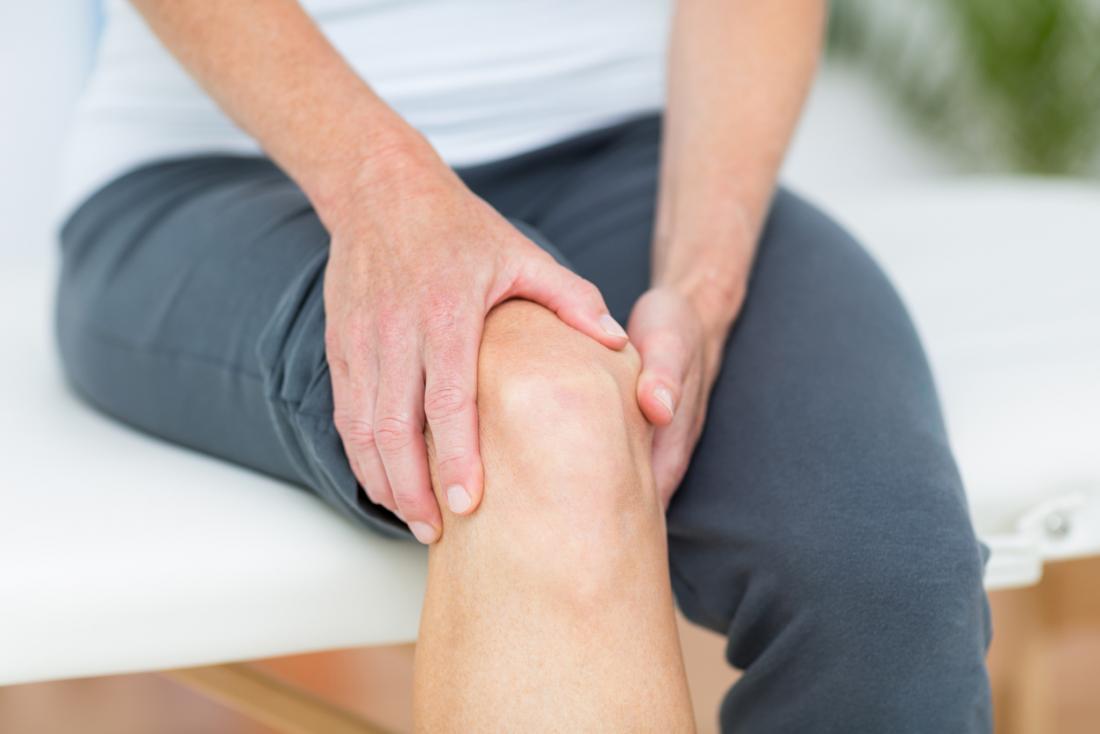 Person experiencing joint pain in their knee.