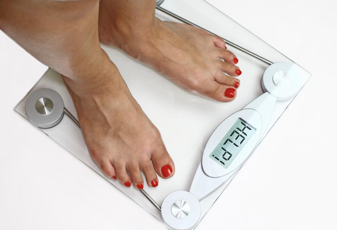 a woman weighing herself on a set of scales