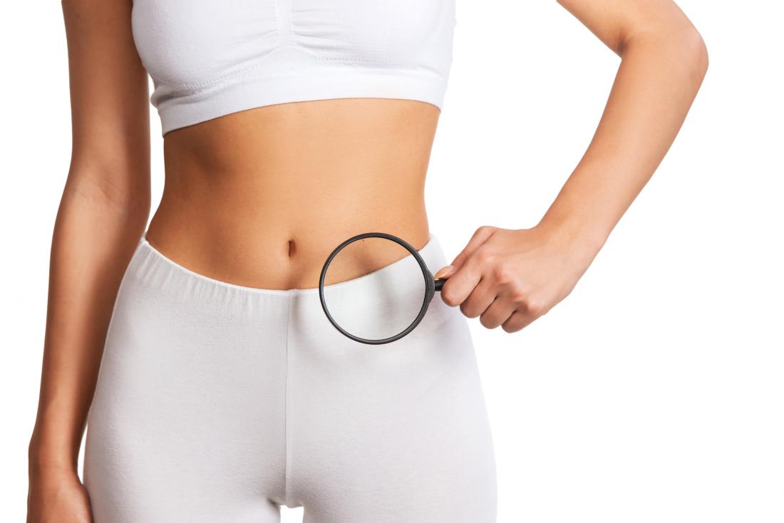 woman holding magnifying glass over abdomen