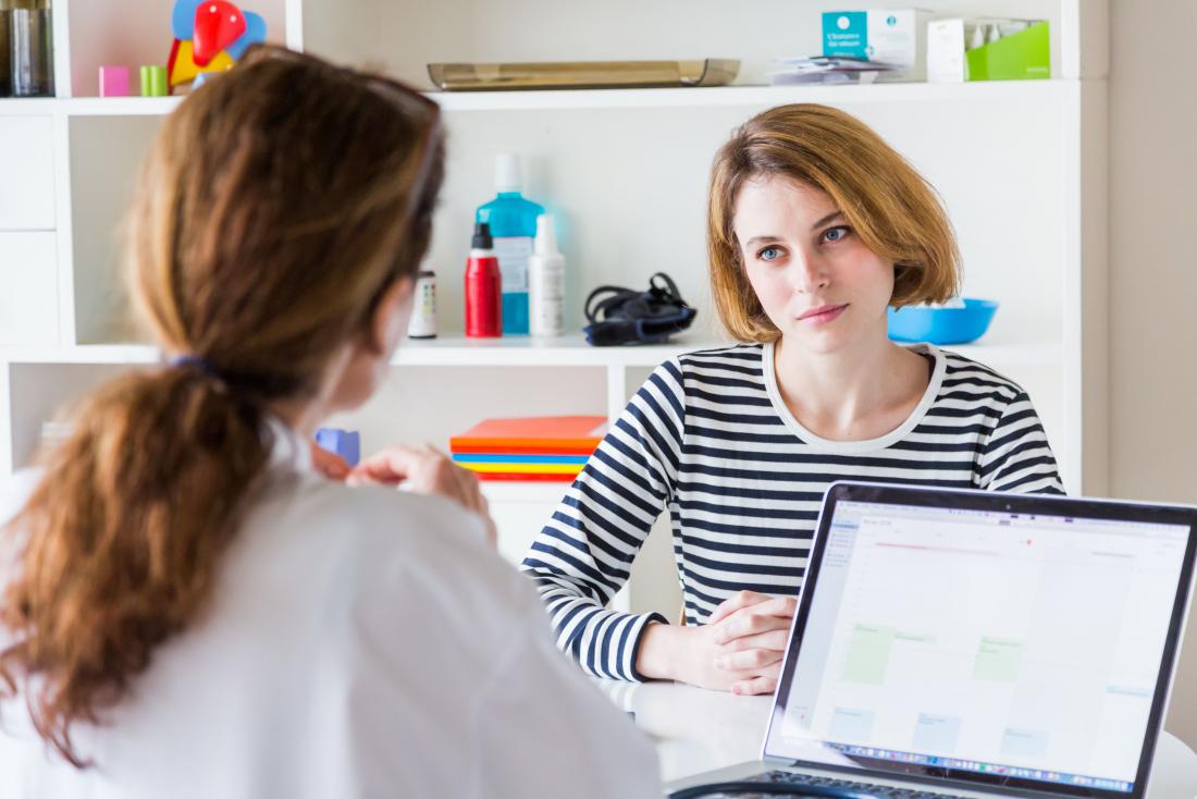 Patient with end stage liver disease due to hepatitis c in doctor's office sitting across from gp