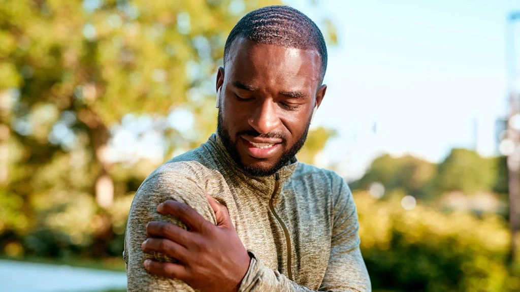 a man holding his shoulder because he has Neuropathic pain there