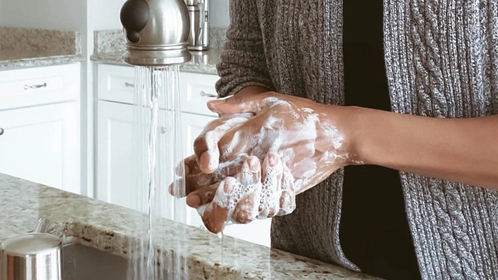 a woman washing her hands because it helps her stay healthy with her weak immune system