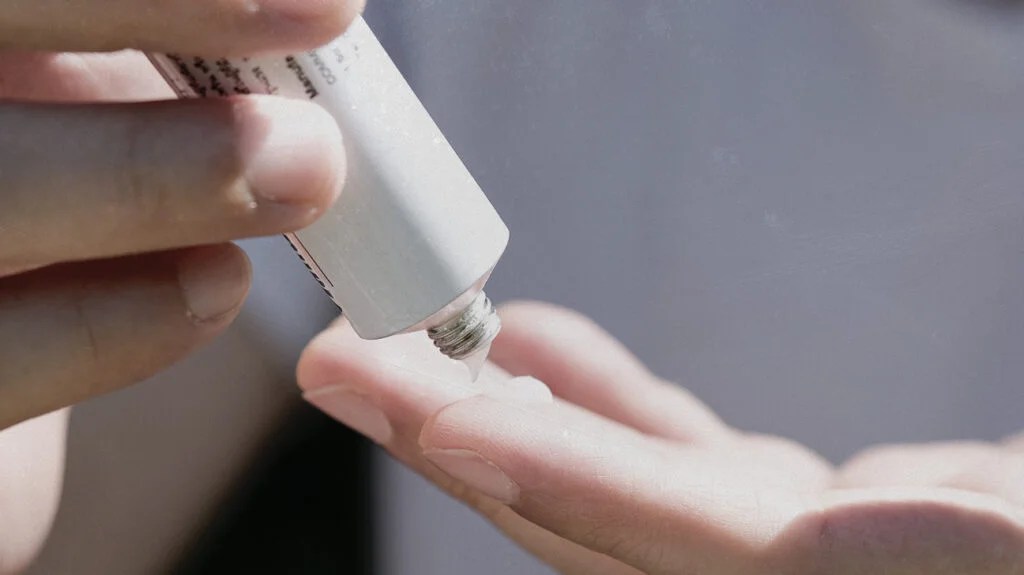 A person applying a steroid cream to treat their eczema.