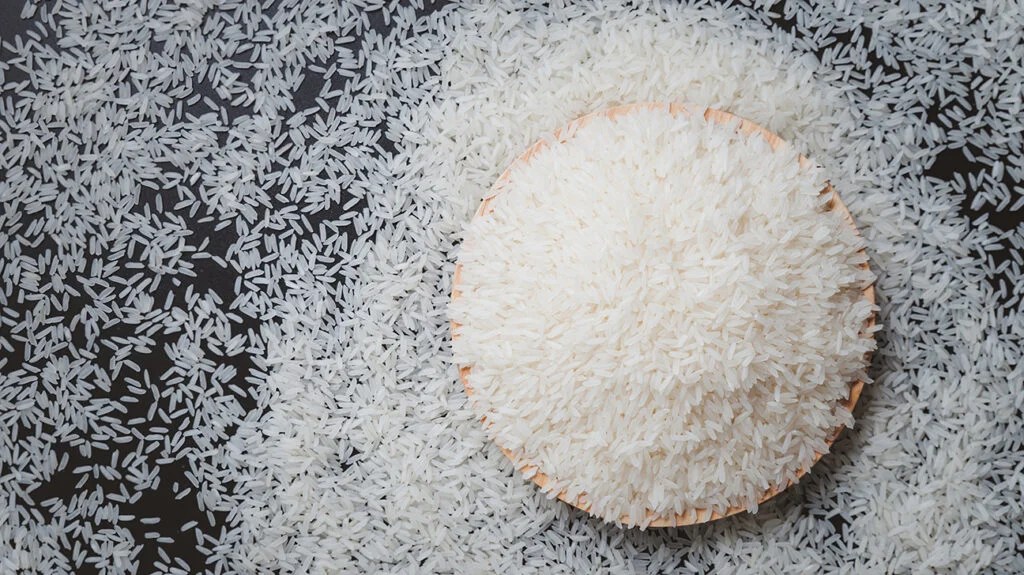 An overflowing bowl of white rice grains.