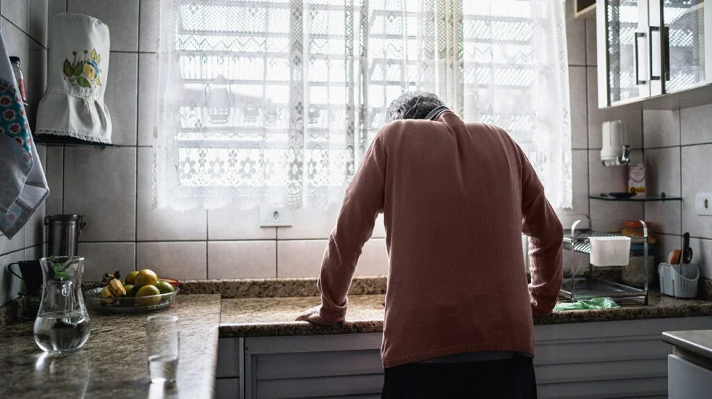 a person with chest pain is leaning over a kitchen counter