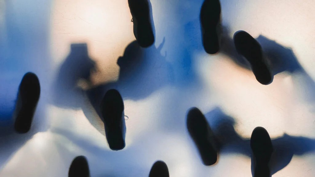 A view from below showing the outline of people's shoes.