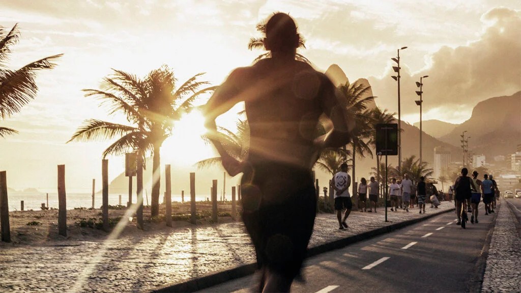 Man jogging on the beach of Ipanema at sunset