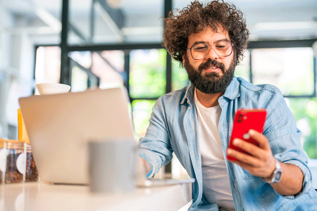 Young bearded man sitting at laptop and talking with dermatologist about health information he found online.