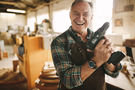 older man holding a drill