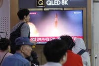 A TV screen shows a file image of North Korea's missile launch during a news program