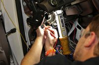 Mechanic working on a car's starting system.