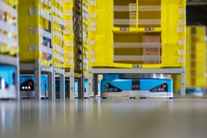 Amazon robots sit under fulfillment center racks.