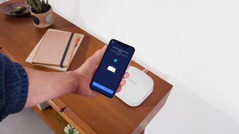 Person activating contactless Wi-Fi with iPhone and an eero device