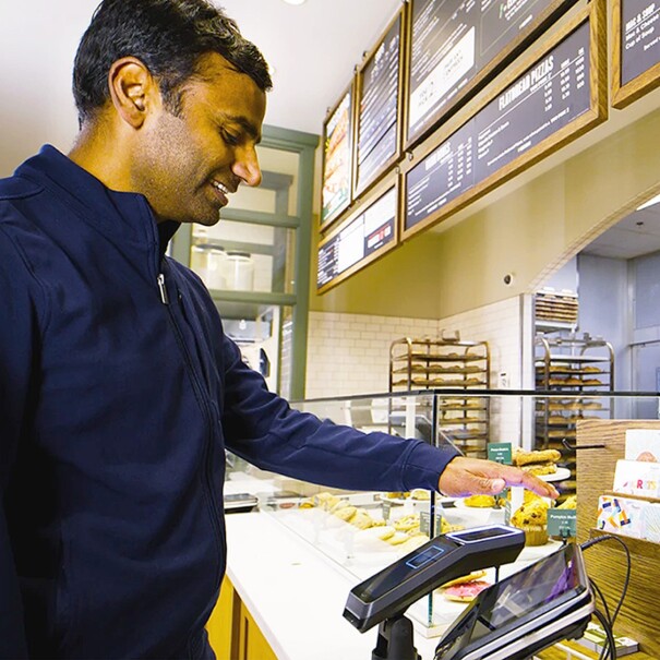 A man pays using Amazon One at a Panera store.