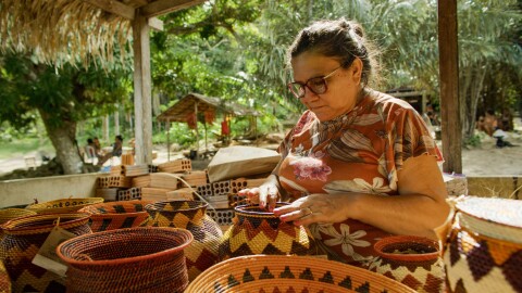 Woman sitting and working on crafted baskets