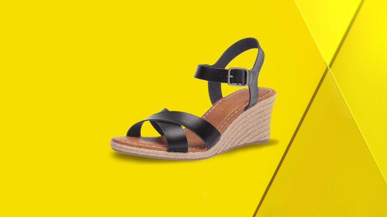 Black wedge sandals on yellow background