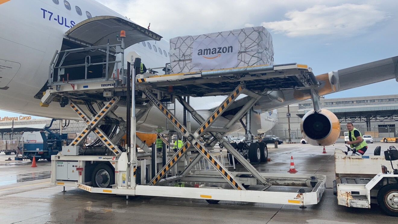 A supply package with the Amazon logo on it being boarded onto a freight plane to be sent to Nepal.