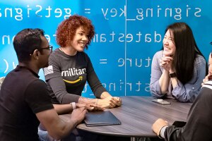 A photo of an Amazon lead within the military spouse fellowship program sitting at a round table with three individuals.