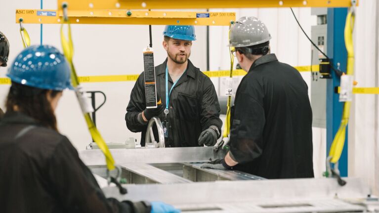 Industrial workers in protective gear reviewing procedures