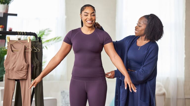 A photo of Toyin Omisore, owner and CEO, Roam Loud, fitting athletic clothes on a model.