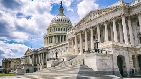 The U.S. Capitol, shown with no people in the image, in front of a blue sky with some visible clouds