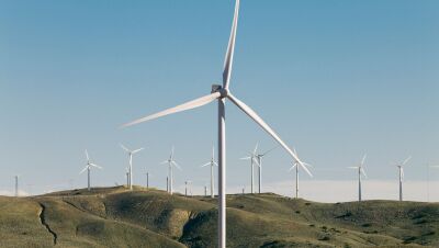 Wind farm on rolling hills with rows of turbines