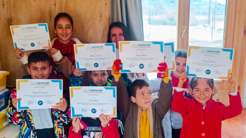 Children in Hatay, Turkey holding certificates at the Smiling Dreams Community House 