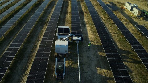 Overhead shot of workers at a solar power station working with AI-powered robot