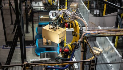 A robotic arm in an Amazon fulfillment center helps sort packages for delivery. 