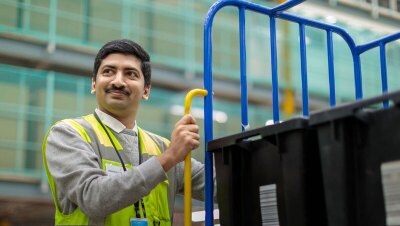 An image of an Amazon employee wearing a vest and looking to the left side. 