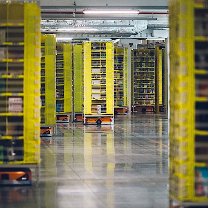 Robots carrying columns of packages in an Amazon fulfillment center. 