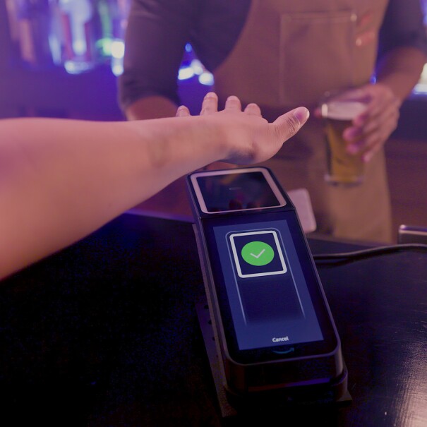 A photo of a customer paying for a beer at a bar using Amazon One.