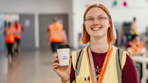 Eine Amazon Mitarbeiter hält einen Kaffeebecher mit de Aufschrift "You matter!"