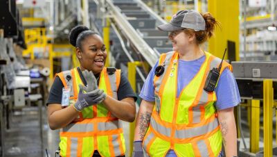 Amazon employees wear safety vests in a fulfillment center