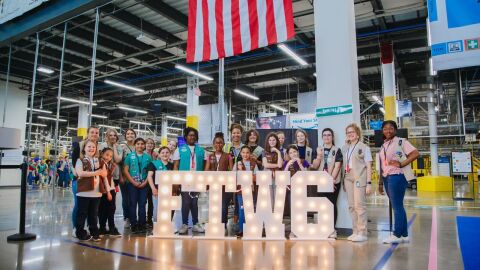 An image of Girl Scouts touring an Amazon fulfillment center.