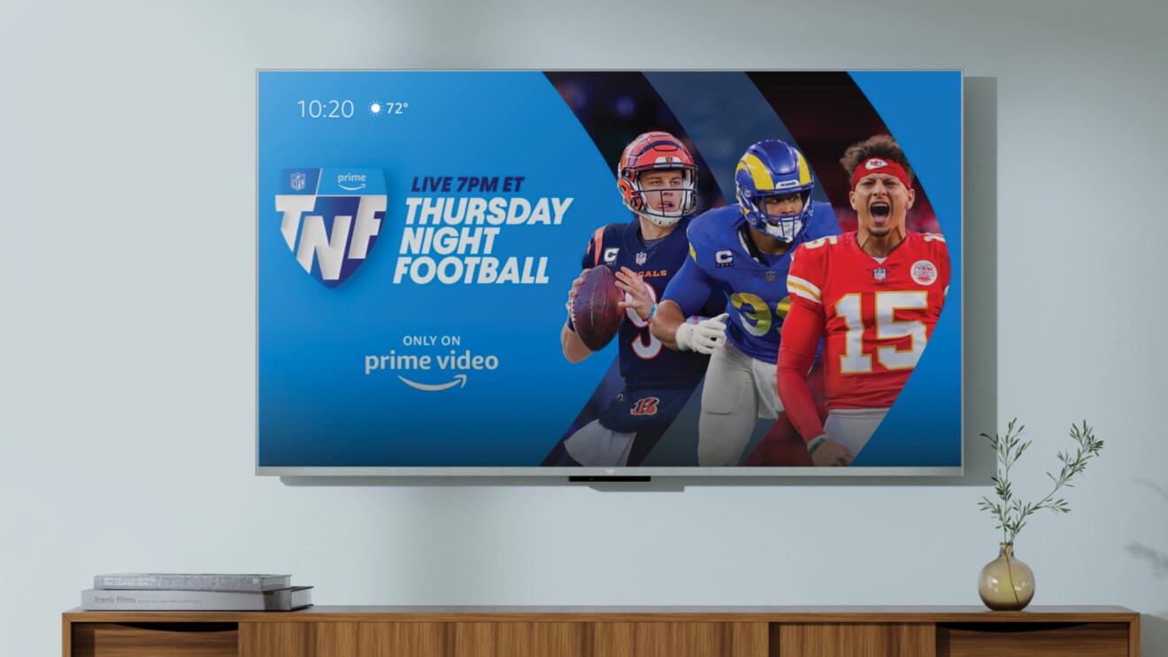 An image of the Fire TV Cube with Prime Video's "Thursday Night Football" cover on the screen and a wooden entertainment center at the bottom. 