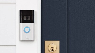 Image of a Ring doorbell next to a front door. 