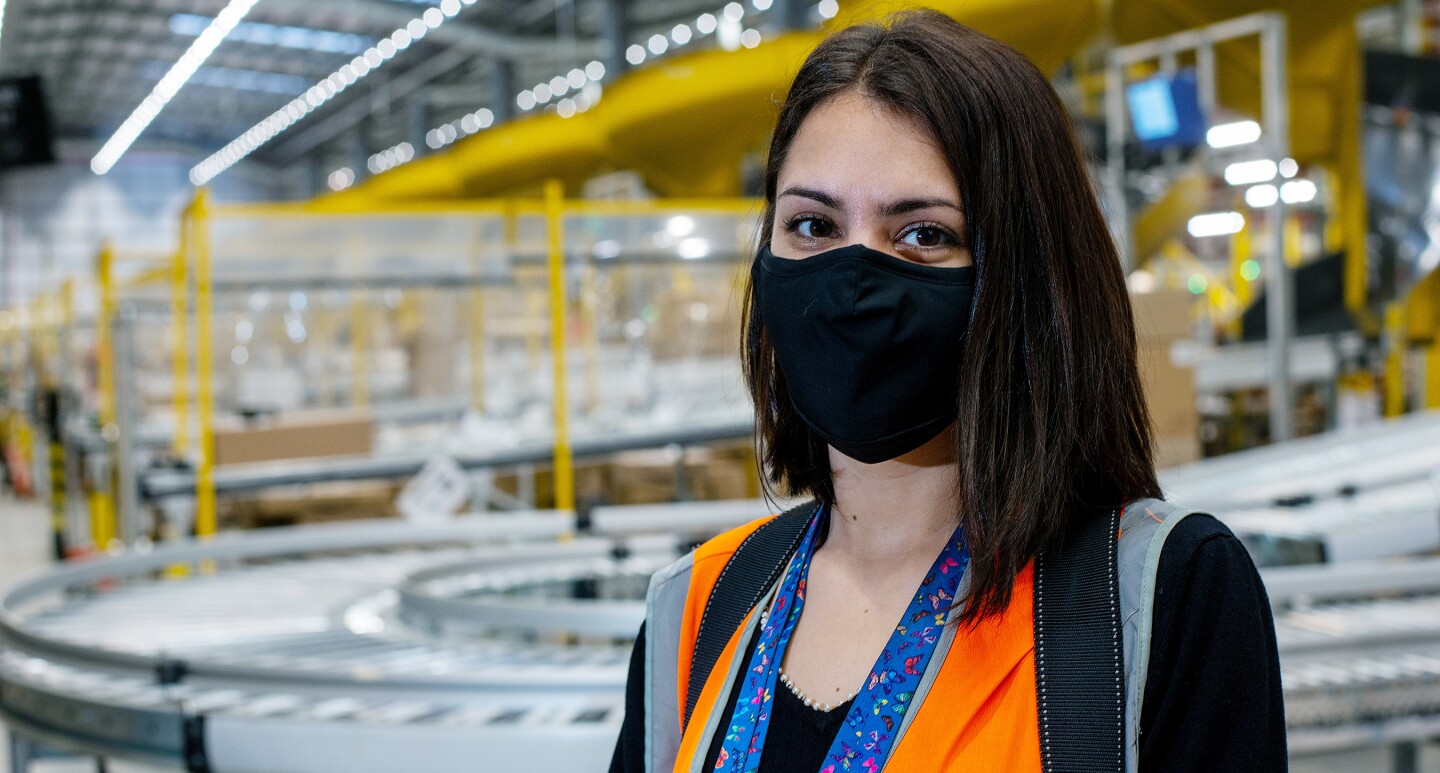 Teodora Halmagean, wearing a facemask and standing in an Amazon Fulfilment Centre in Doncaster. 