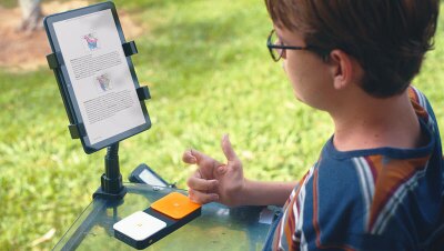 An image of a boy reading from a Kindle device. 