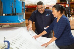 A photo of two Compac Industries employees observing material in a factory.