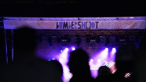 The 2023 Seattle Bumbershoot festival stage at night with attendees in the forefront.